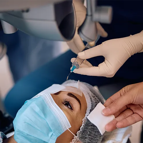 Procedimento de vitrectomia em sala cirúrgica, com paciente deitada e equipe médica utilizando equipamento oftalmológico avançado.