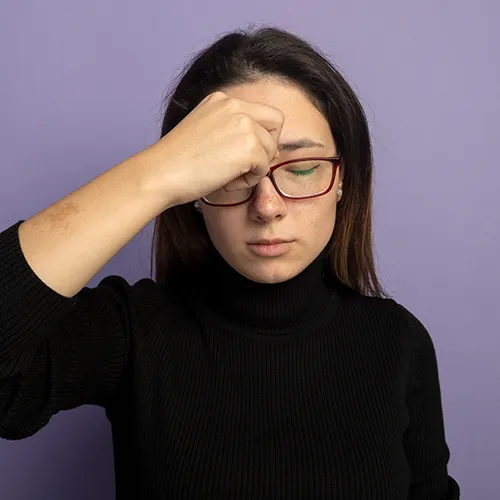 jovem com as mãos no rosto, sofrendo com visão subnormal nos hospitais de olhos da Rede Vision One